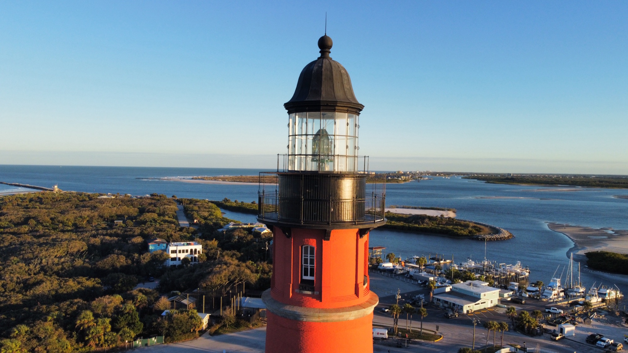 Aerial drone photograph of the Ponce de Leon Inlet lighthouse at golden hour, Florida coast